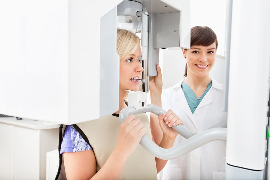 A young dentist taking a panoramic digital X-ray of a patient`s teeth