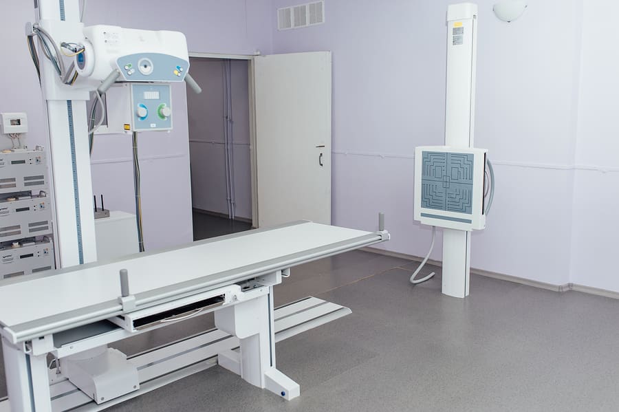 X-ray room in a hospital ER operating room with a classic ceiling-mounted x-ray system. Modern medical equipment, interventional medicine and healthcare concept.